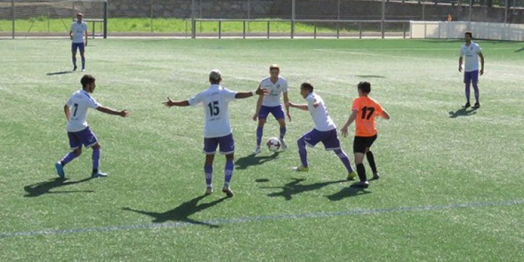 Jugadors del CE Carroi protegint la pilota en el partit davant La Massana.