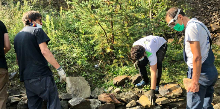 Els joves aprenen a construir un mur amb la tècnica de la pedra seca.