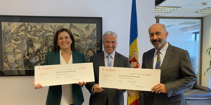 El ministre de Salut, Joan Martínez Benazet, i el sotsdirector general de Banca País d'Andbank, Josep Maria Cabanes, lliuren el xec a Càndida Castillo, directora de l'obra social de l'hospital Sant Joan de Déu.