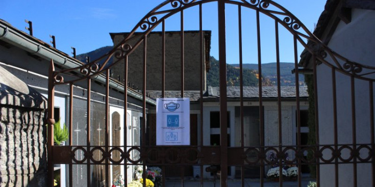 La porta d’entrada al cementiri vell de la Massana, amb un cartell anunciador de les mesures.