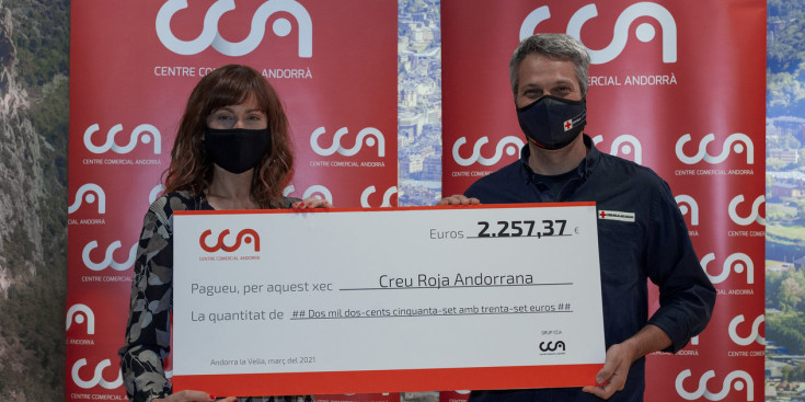 La directora de Màrqueting del CCA, Montse Resina, entrega el xec al director de la Creu Roja Andorrana, Jordi Fernández.