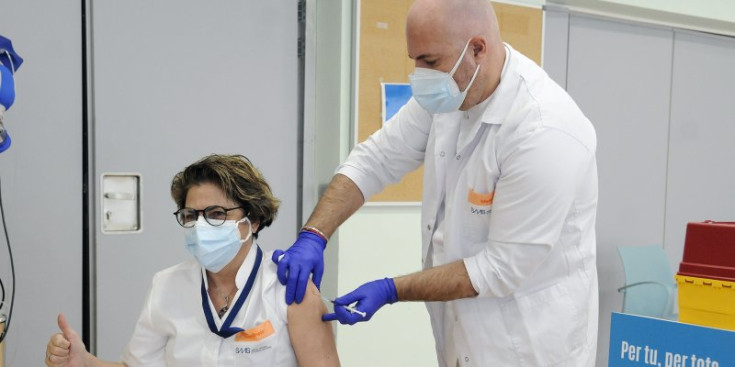 Una infermera rep la primera dosi de la vacuna.