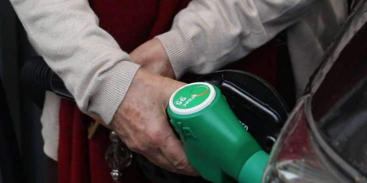 Una persona posa carburant al seu vehicle.