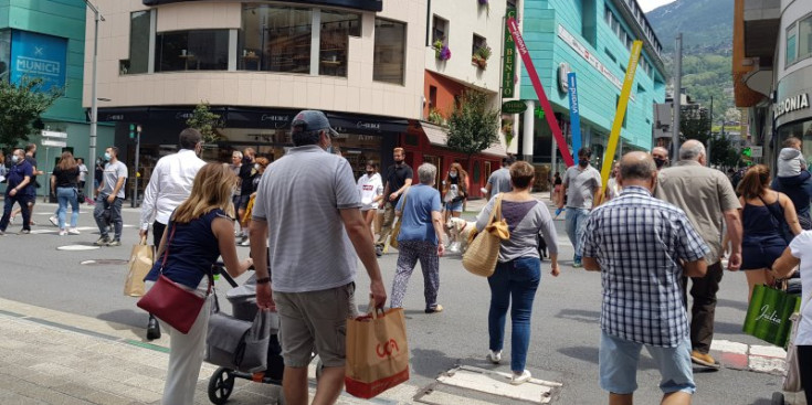 Turistes i visitants passegen per l’eix comercial del centre, ahir.