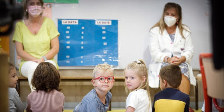 Una professora i alumnes de primera ensenyança, dijous passat.