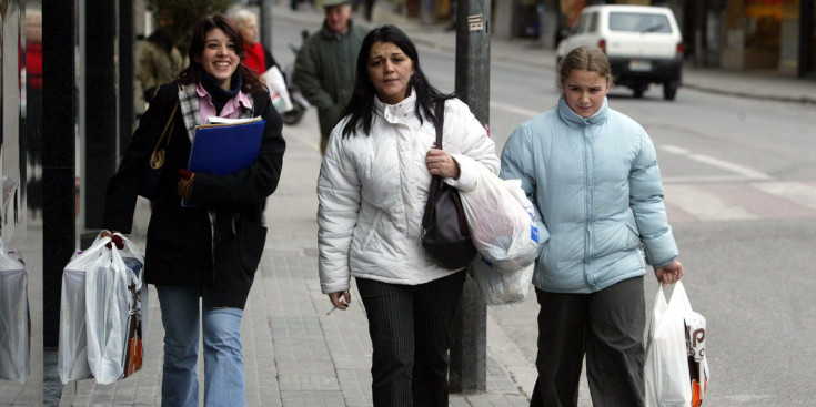 Tres dones treballadores caminant pel carrer.