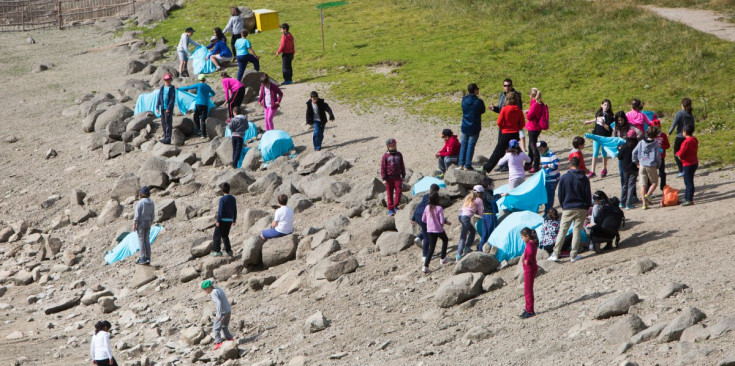 Un grup d’alumnes de l’Escola Andorrana de la Massana i del Pas de la Casa cobreixen roques amb teles blaves, ahir al llac d’Engolasters.