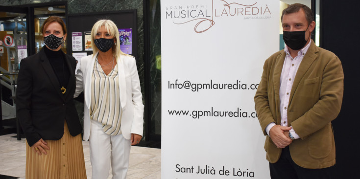 Els cònsols de Sant Julià de Lòria, Josep Majoral i Mireia Codina, i la directora del Gran Premi Musical Lauredià, Roser Palomero, amb el cartell de l'esdeveniment.