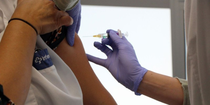 Una infermera es posa una dosis de vacuna de la grip.
