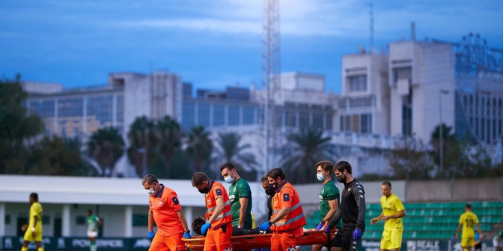 El porter Íker Álvarez retirat pels operaris sanitaris després de rebre un fort cop al cap.