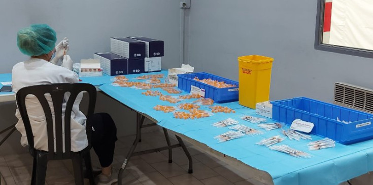 Imatge d’arxiu d’una sanitària preparant dosis de la vacuna a la plaça de braus.