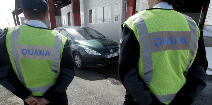 Dos agents de la duana amb França controlen l’entrada de vehicles.