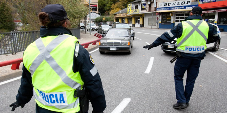 Dos agents de la Policia aturen els vehicles en un control a Sant Julià de Lòria.