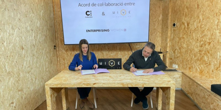 Lara de Miguel i Manel Garcia signen l’acord de col·laboració.