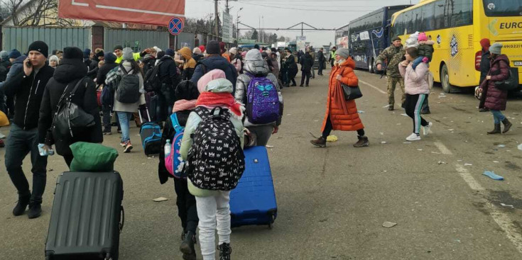 Ciutadans ucraïnesoes caminen per la frontera amb maletes per sortir del país.