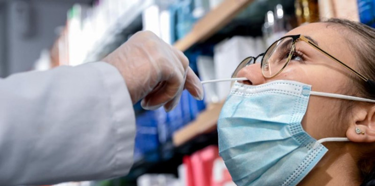Una noia se sotmet a un test d’antígens en una farmàcia.