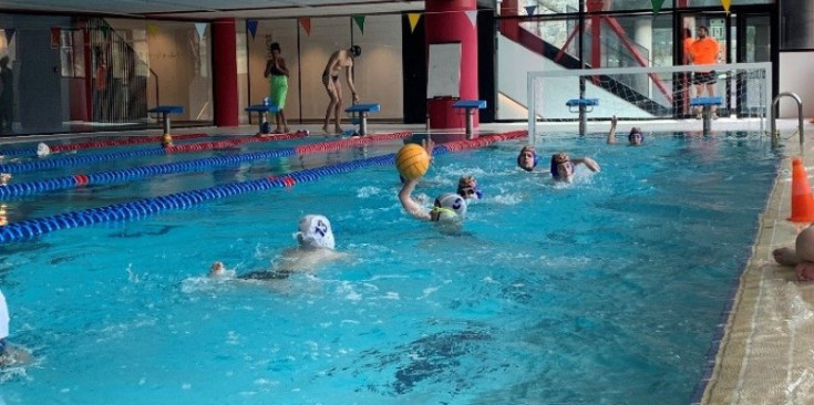 Uns nens gaudeixen de jugar a waterpolo.