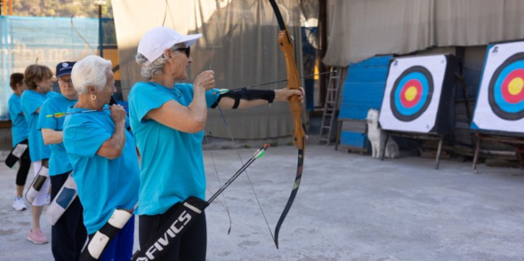 Una dona gran practicant tir amb arc.