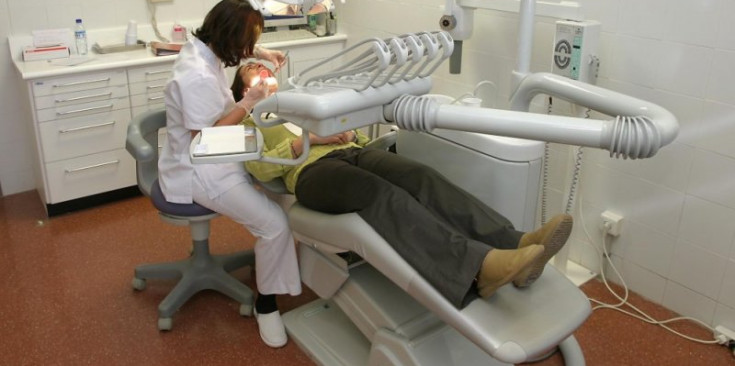 Una dentista atén una pacient en una consulta.