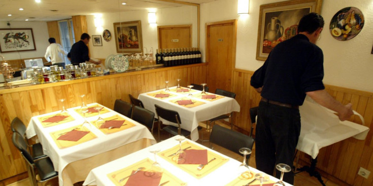 Un cambrer prepara les taules en un restaurant andorrà.