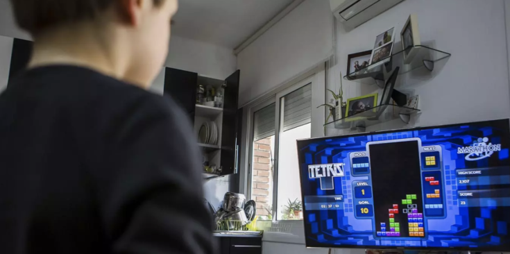 Un nen jugant al Tetris a través de la televisió.