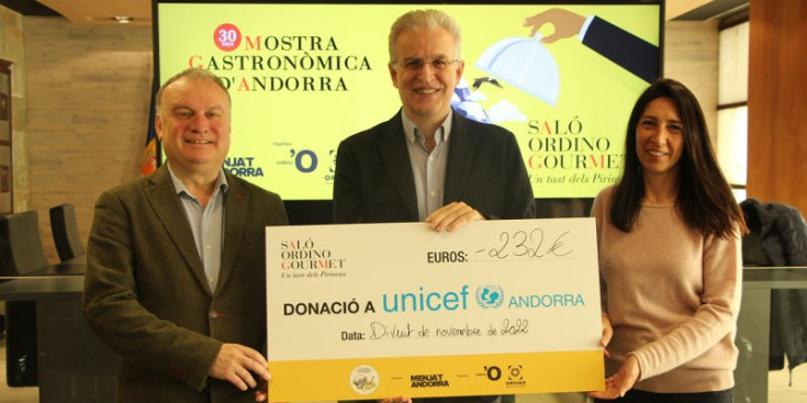 El director d’Unicef, Albert Mora, rep el xec de mans de Toni Corominas, director de Menja’t Andorra, empresa organitzadora del saló, i la cònsol menor i consellera d’Educació, Joventut i Cultura d'Ordino, Eva Choy.