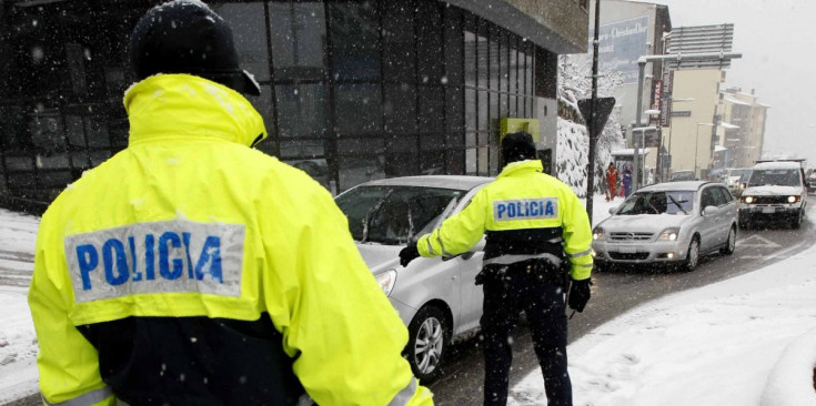 Agents de la Policia controlen els vehicles en una forta nevada.