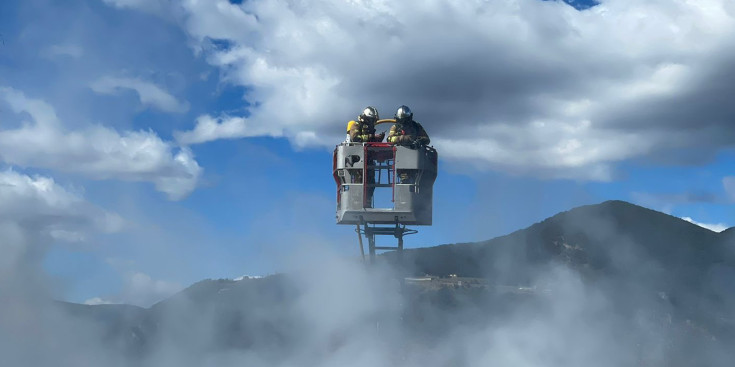 Dos bombers treballant en un incendi.