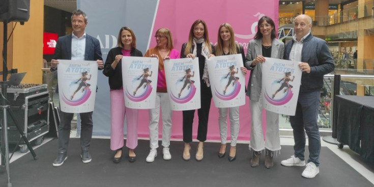 David Astrié, Rosa Gili, Mònica Codina, Helena Mas, Mariona Cadena, Cristina Royo-Cebrecos i Javi Jiménez amb el cartell de la 11a Cursa de la Dona.