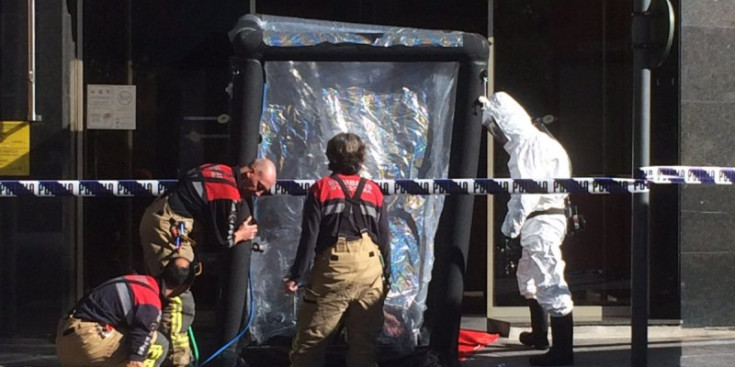 Membres del cos de bombers col·loquen la cabina de descontaminació a la porta de La Poste
