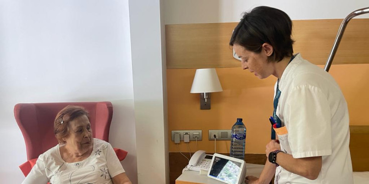 Una infermera explicant a una pacient com funciona el dispositiu intel·ligent.