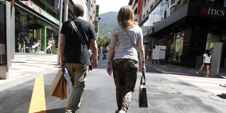 Dos turistes passegen per l’avinguda Carlemany, aquest estiu.