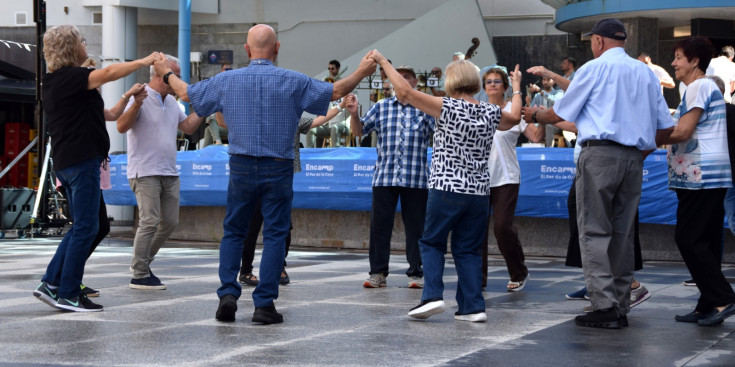 Un grup de persones ballant sardanes a la plaça dels Arínsols d'Encamp.