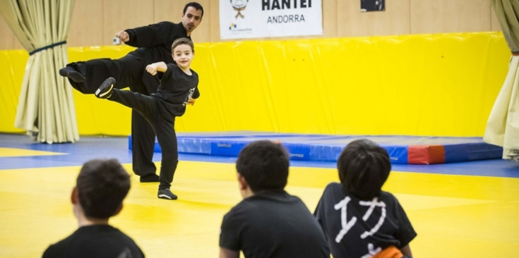 Un entrenador donant unes indicacions a uns joves esportistes.