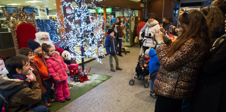 Turistes fotografiant-se amb el Pare Noel a l’Avinguda Meritxell.