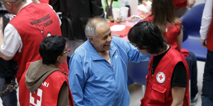 Un grup de voluntaris de la Creu Roja andorrana amb una persona de la tercera edat celebrant el dia internacional de l’entitat.