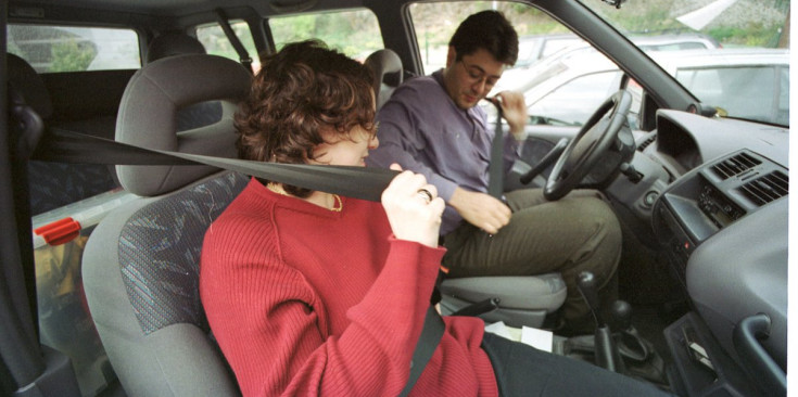 Un conductor i una passatgerea es col·loquen el cinturó de seguretat.