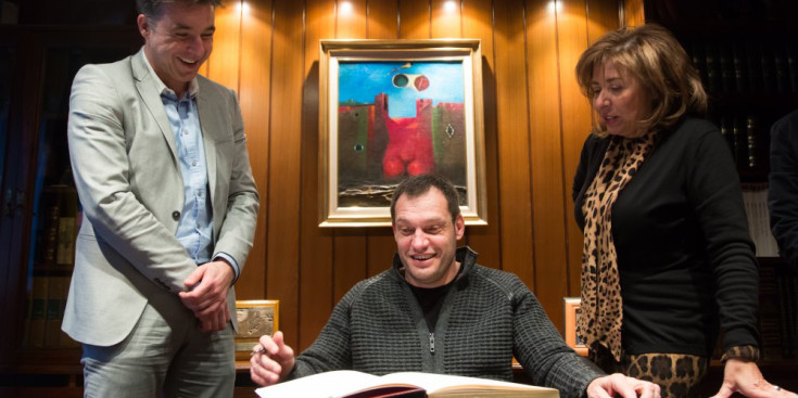 Albert Llovera signa el Llibre d’or del Comú d’Andorra la Vella, sota la mirada de Marc Pons i Conxita Marsol.