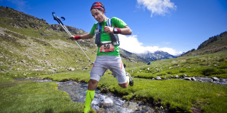 Un corredor supera amb un salt un rierol a l’Andorra Ultra Trail Vallnord de l’any passat.