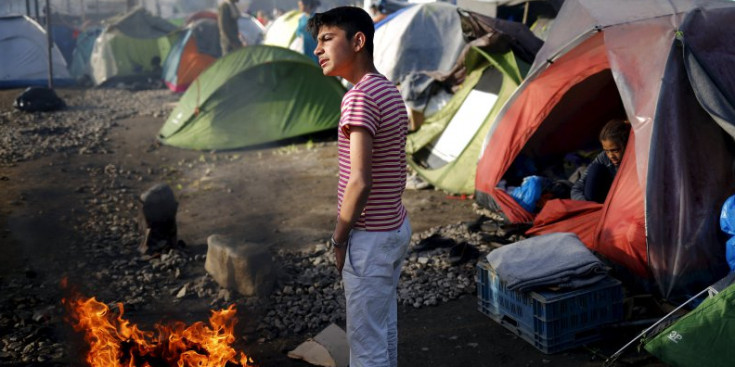 Un jove al costat d’un foc, en el campament d’Idomeni, ahir.