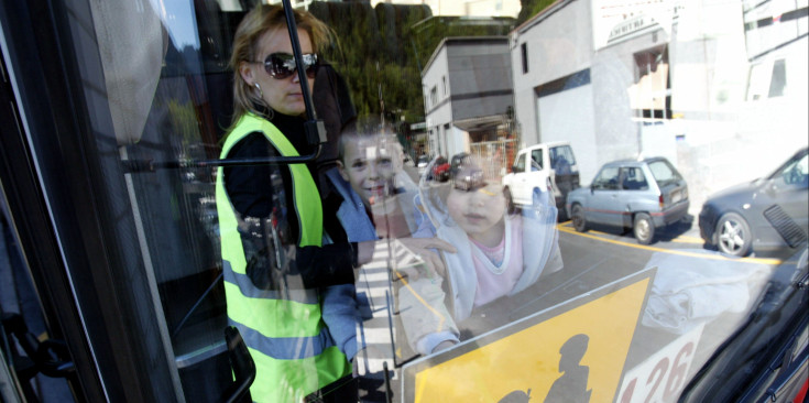 Una vigilant i infants a l’interior d’un vehicle de transport escolar.