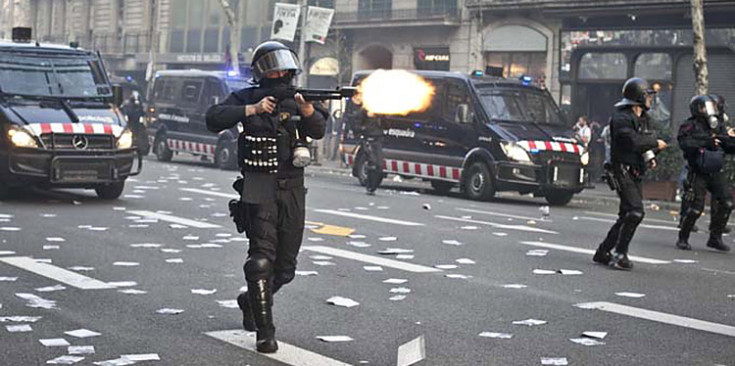 Un Mosso d’Esquadra dispara bales de goma a la plaça de Catalunya en la vaga general del març de 2012.