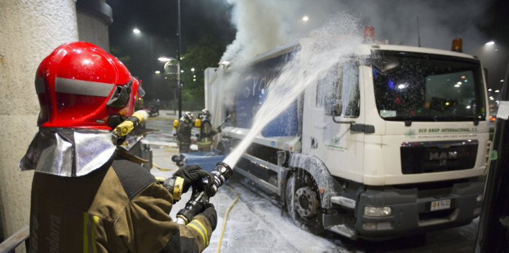 Els bombers extingeixen l’incendi en un camió d’escombraries amb paper i cartró, dijous a la nit.