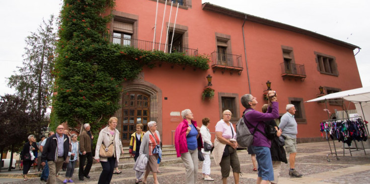 Uns turistes passegen per davant de l’ajuntament urgellenc.