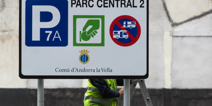 Un treballador arregla un senyal a Andorra la Vella.