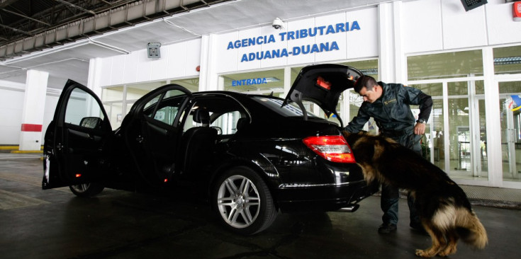 Un agent de la Guàrdia Civil i el seu gos registren un vehicle per si porta tabac o euros de contraban.