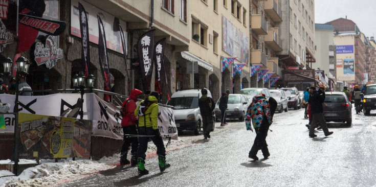Uns esquiadors caminen per un carrer del Pas de la Casa.