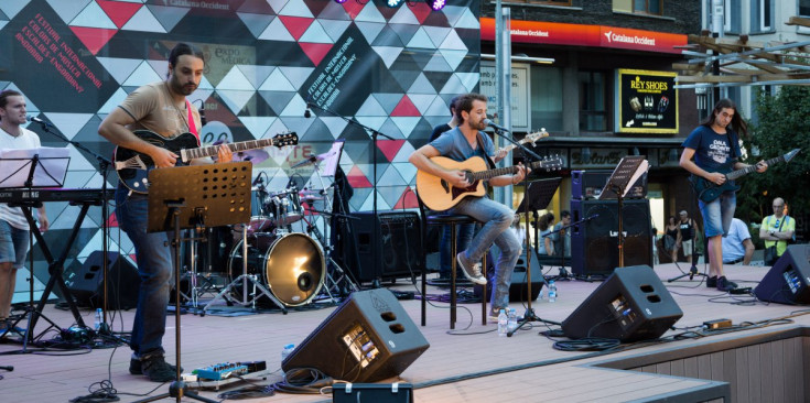 El músic Quim Salvat (al centre, amb la guitarra), durant la seva actuació d’ahir a la plaça Coprinceps.
