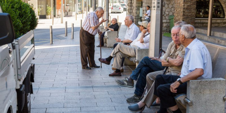 Un grup de jubilats conversen davant del Comú d’Andorra la Vella.