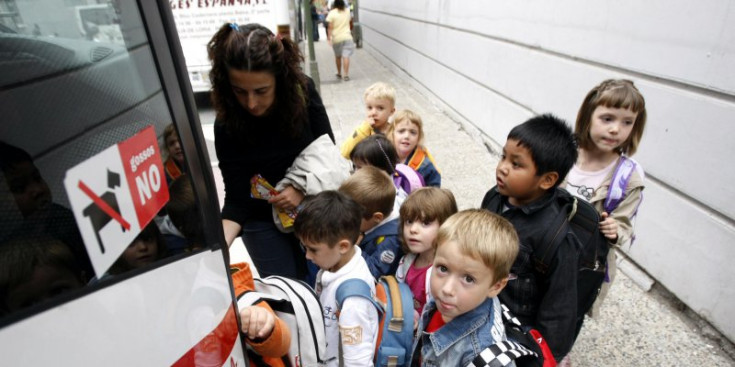Uns nens preparats per pujar en un autobús escolar.